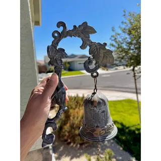 Photo of cast iron wall-mounted doorbell dinner bell scrolling bracket grapevine leaves
