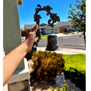 Photo of cast iron wall-mounted doorbell dinner bell scrolling bracket grapevine leaves